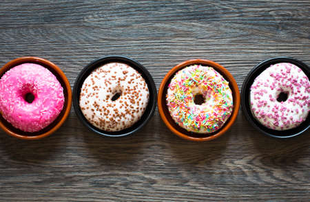 Morning breakfast with colorful Donuts on a rustic wooden background. Top viewの写真素材