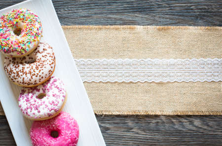 Morning breakfast with colorful Donuts on a rustic wooden background. Top viewの写真素材