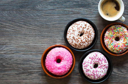 Morning breakfast with colorful Donuts and expresso coffee on a rustic wooden background. Top viewの写真素材