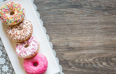 Morning breakfast with colorful Donuts on a rustic wooden background. Top viewの写真素材