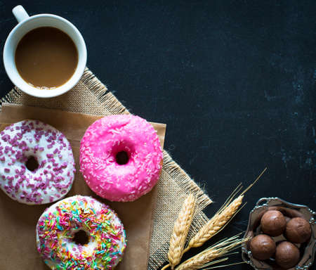 Morning breakfast with colorful Donuts and expresso coffee on a rustic wooden background. Top viewの写真素材