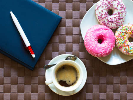 Morning breakfast with colorful Donuts and expresso coffee on a rustic wooden background. Top viewの写真素材