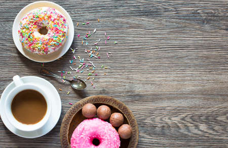 Morning breakfast with colorful Donuts on a rustic wooden background. Top viewの写真素材