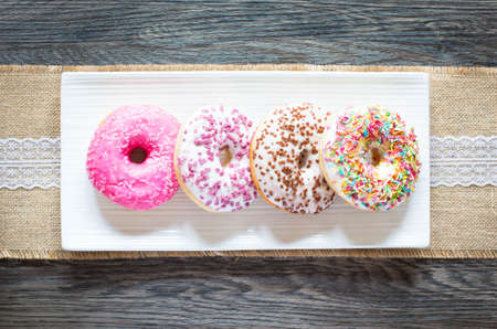Morning breakfast with colorful Donuts on a rustic wooden background. Top viewの写真素材