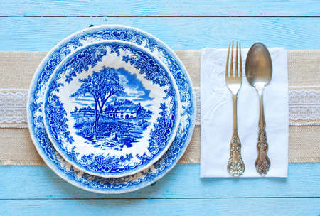 Hand painted plate with fork and spoon on wooden backgroundのeditorial素材