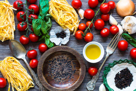 Italian food cooking ingredients for tomato pasta with vegetables and spices. Top view on wooden backgroundの写真素材