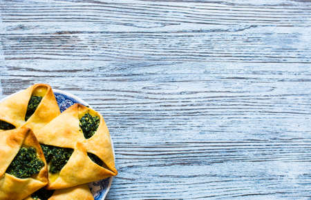 Spinach pie with ricotta cheese, on a wooden background.の写真素材