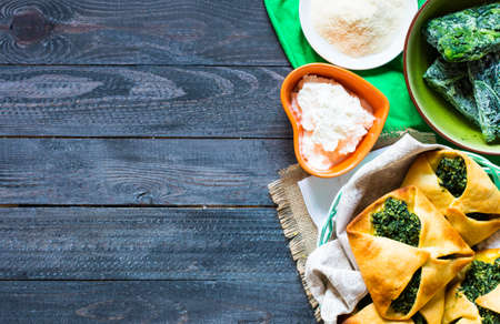 Spinach pie with ricotta cheese, on a wooden background.の写真素材