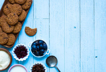 Healthy morning breakfast with cereal biscuits, dried cranberries and grapes, over a wooden table background.の写真素材