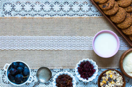 Healthy morning breakfast with cereal biscuits, dried cranberries and grapes, over a wooden table background.の写真素材