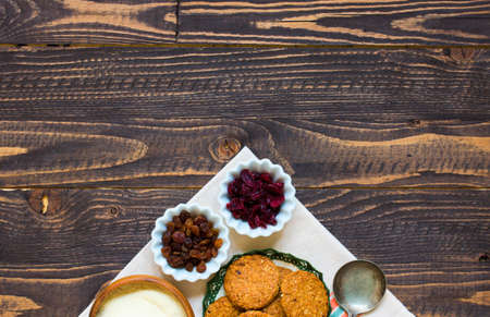 Healthy morning breakfast with cereal biscuits, dried cranberries and grapes, over a wooden table background.の写真素材