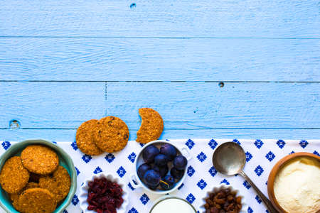 Healthy morning breakfast with cereal biscuits, dried cranberries and grapes, over a wooden table background.の写真素材