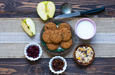 Healthy morning breakfast with cereal biscuits, dried cranberries and grapes, over a wooden table background.の写真素材