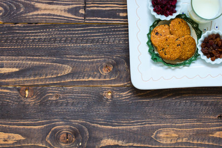 Healthy morning breakfast with cereal biscuits, dried cranberries and grapes, over a wooden table...