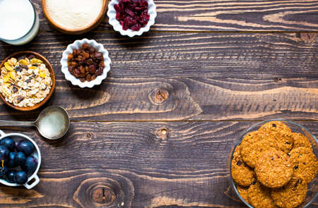 Healthy morning breakfast with cereal biscuits, milk, dried cranberries over a wooden table background.の写真素材