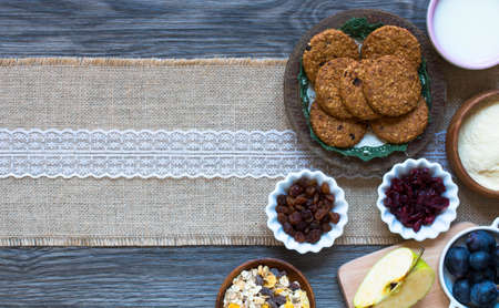 Healthy morning breakfast with cereal biscuits, dried cranberries and grapes, over a wooden table background.の写真素材