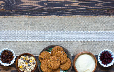Healthy morning breakfast with cereal biscuits, dried cranberries and grapes, over a wooden table background.の写真素材