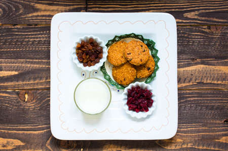 Healthy morning breakfast with cereal biscuits, dried cranberries and grapes, over a wooden table background.の写真素材