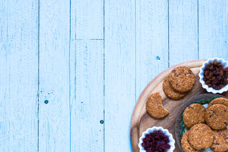 Healthy morning breakfast with cereal biscuits, dried cranberries and grapes, over a wooden table background.の写真素材