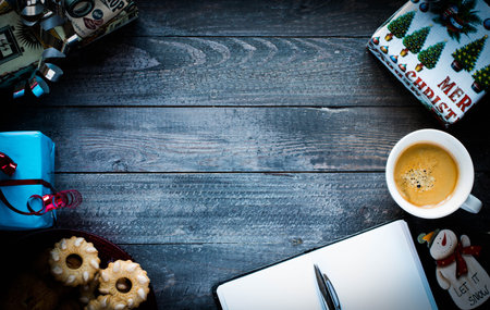 Christmas hand baked biscuits background with a lot of seasonal objects, coffee, spieces,eggs, sugar  on a wooden old table.の写真素材