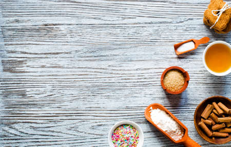 Christmas hand baked biscuits background with a lot of seasonal objects, coffee, spieces,eggs, sugar  on a wooden old table.の写真素材