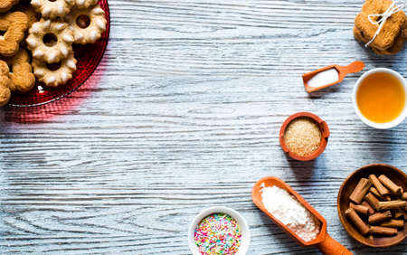 Christmas hand baked biscuits background with a lot of seasonal objects, coffee, spieces,eggs, sugar  on a wooden old table.の写真素材