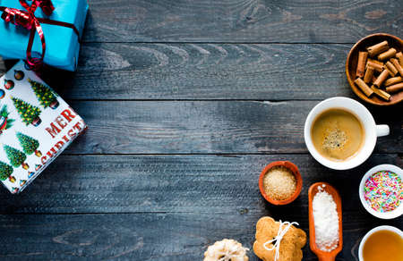 Christmas hand baked biscuits background with a lot of seasonal objects, coffee, spieces,eggs, sugar  on a wooden old table.の写真素材
