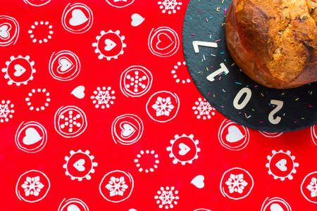 Panettone with chocolate and Christmas decoration on a rad backgroundの写真素材