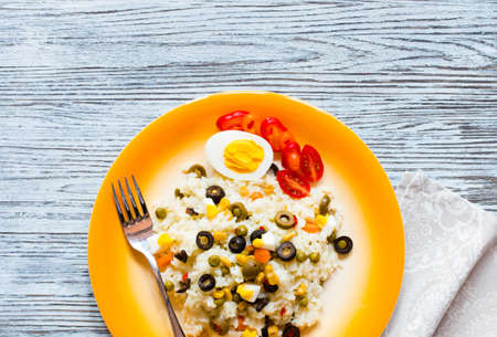 Vegetarian fresh salad with white rice and fresh colourful vegetables on wooden backgroundの写真素材