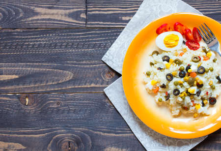 Vegetarian fresh salad with white rice and fresh colourful vegetables on wooden backgroundの写真素材