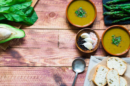 Spinach cream soup with asparagus, croutons and olives, on rustic backgroundの写真素材