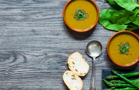 Spinach cream soup with asparagus, croutons and olives, on rustic backgroundの写真素材