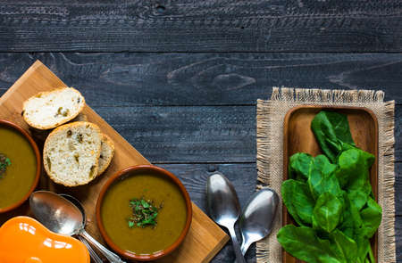 Spinach cream soup with asparagus, croutons and olives, on rustic backgroundの写真素材