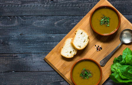 Spinach cream soup with asparagus, croutons and olives, on rustic backgroundの写真素材
