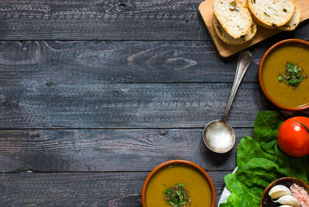 Spinach cream soup with asparagus, croutons and olives, on rustic backgroundの写真素材