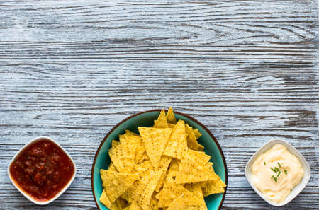 Mexican nachos chips with spicy tomato sauce on wooden backgroundの写真素材