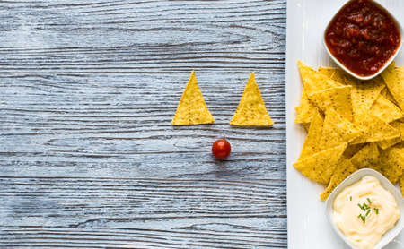 Mexican nachos chips with spicy tomato sauce on wooden backgroundの写真素材