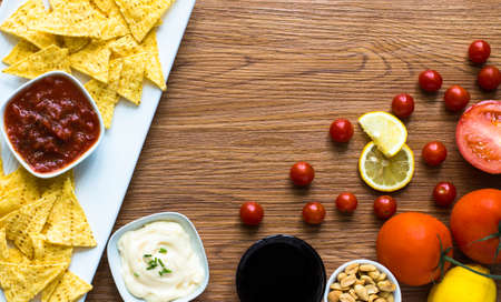 Mexican nachos chips with spicy tomato sauce on wooden backgroundの写真素材