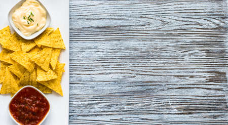 Mexican nachos chips with spicy tomato sauce on wooden backgroundの写真素材
