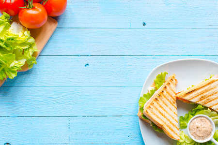 Top view of Healthy Sandwich toast with lettuce, ham, cheese and tomato on a wooden backgroundの写真素材
