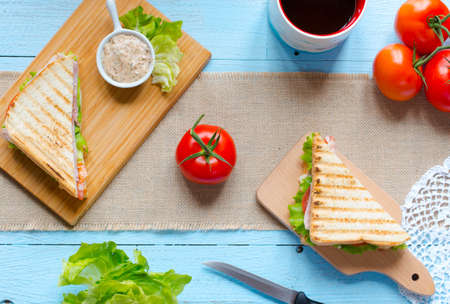 Top view of Healthy Sandwich toast with lettuce, ham, cheese and tomato on a wooden backgroundの写真素材