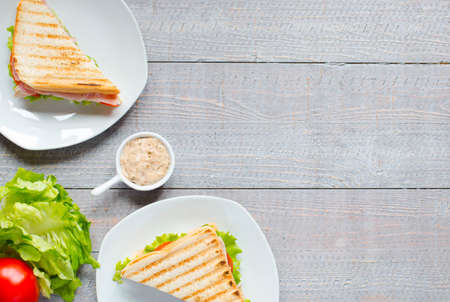 Top view of Healthy Sandwich toast with lettuce, ham, cheese and tomato on a wooden backgroundの写真素材