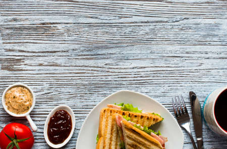 Top view of Healthy Sandwich toast with lettuce, ham, cheese and tomato on a wooden backgroundの写真素材