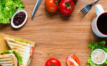 Top view of Healthy Sandwich toast with lettuce, ham, cheese and tomato on a wooden backgroundの写真素材