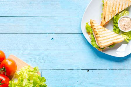 Top view of Healthy Sandwich toast with lettuce, ham, cheese and tomato on a wooden backgroundの写真素材