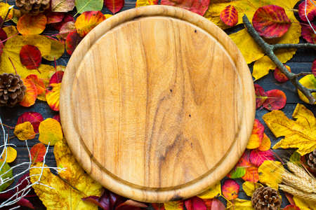 Colorful autumn leaves, yellow, orange and red over a wooden backgroundの写真素材