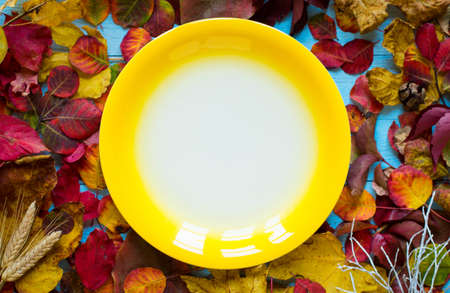 Colorful autumn leaves, yellow, orange and red over a wooden backgroundの写真素材