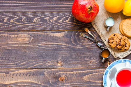Fruit tea with, lemon, milk,honey,orange, pomegranate and brown sugar, on a wooden backgroundの写真素材