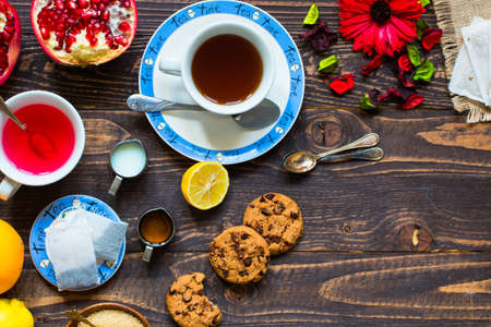 Fruit tea with, lemon, milk,honey,orange, pomegranate and brown sugar, on a wooden backgroundの写真素材