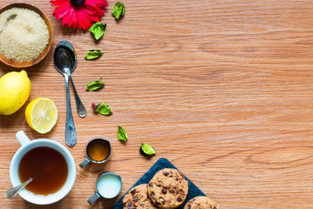 Fruit tea with, lemon, milk,honey,orange, pomegranate and brown sugar, on a wooden backgroundの写真素材